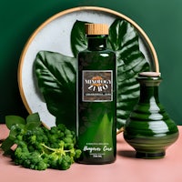 a bottle of green tea and a vase with green leaves