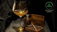 a glass of tea with a cinnamon stick and a wooden box