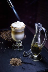 a latte is being poured into a glass