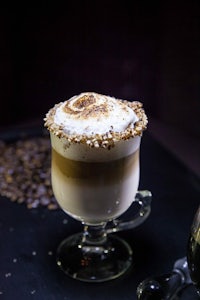 a cup of coffee with whipped cream and coffee beans