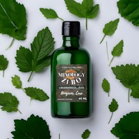 a bottle of mint oil surrounded by leaves