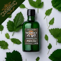 a bottle of mint oil surrounded by leaves