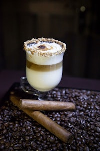 a cup of coffee with whipped cream and cigars