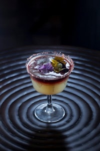 a margarita is sitting on top of a black table